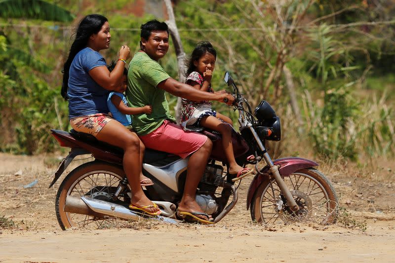 Indigenous people from Guajajara ethnic group are seen on a motorcycle before members of the Brazilian Armed Forces medical team examine them in the indigenous village of Morro Branco