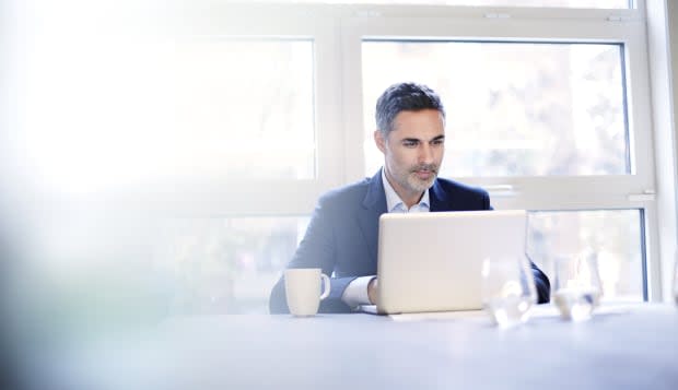 Businessman working on a laptop with a coffee.