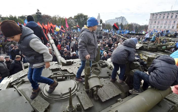 Children play on a tank during a military exhibition to mark Defender's Day in Kiev on October 14, 2015 (AFP Photo/Genya Savilov)