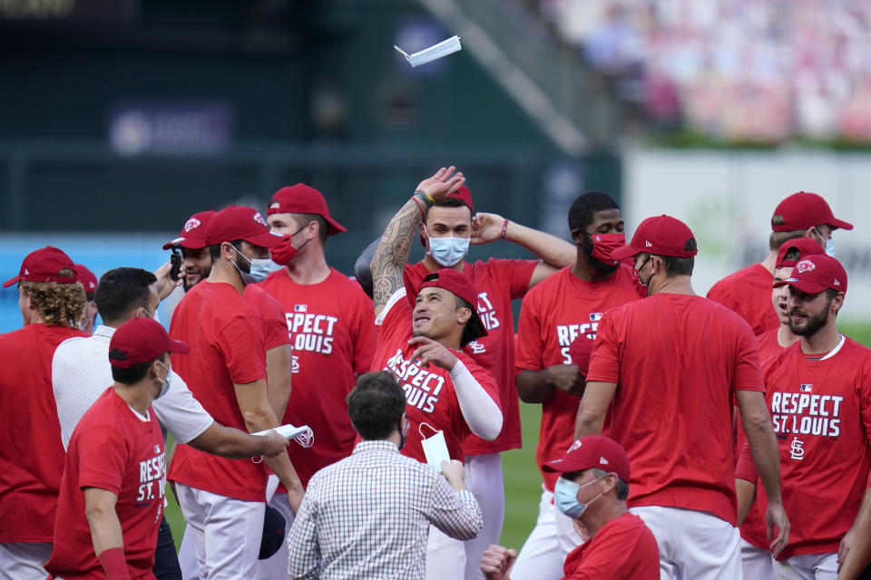 St. Louis Cardinals' Kolten Wong throws a face mask in the air as he celebrates with teammates after defeating the Milwaukee Brewers in a baseball game to earn a playoff birth Sunday, Sept. 27, 2020, in St. Louis. (AP Photo/Jeff Roberson)