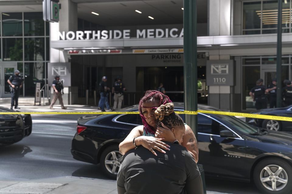 Angela Cooper and Jamese Nathan embrace outside of Northside Hospital medical facility as police officers work the scene of a shooting on May 3, 2023 in Atlanta, Georgia. Police say one person was killed and four others injured in the shooting and the suspect is still at large. 