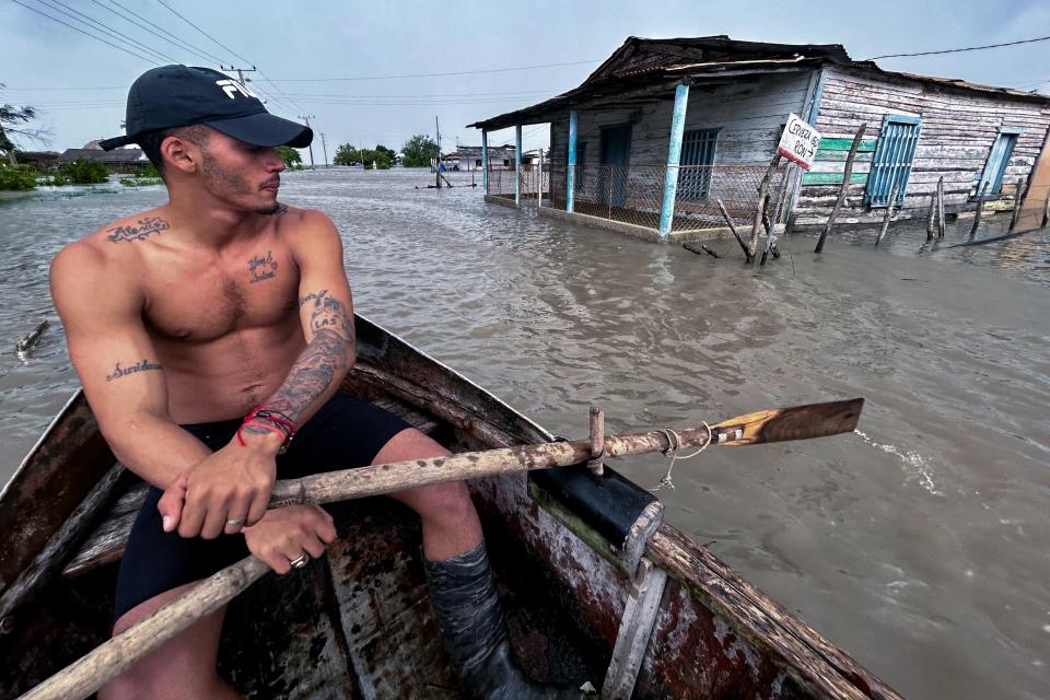 Man sails on a boat in a flooded street after the passage of Hurricane Helene in Guanimar, Cuba (AFP via Getty Images)