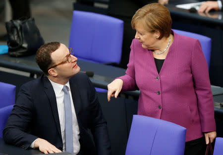 Chancellor Angela Merkel talks to Jens Spahn during debate at the German lower house of parliament Bundestag in Berlin, Germany, February 22, 2018. REUTERS/Axel Schmidt/Files