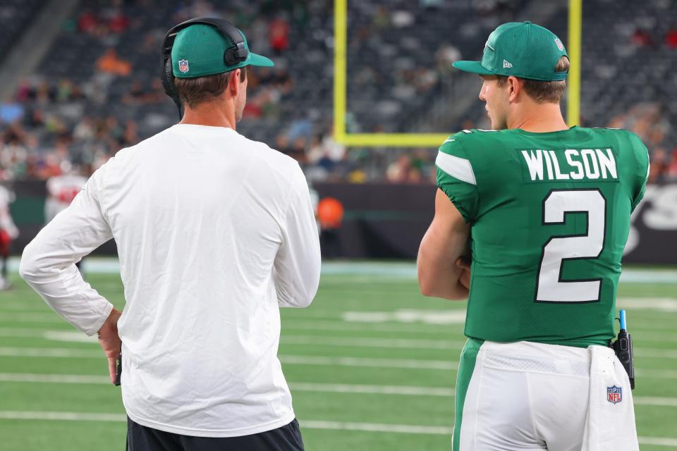 New York Jets quarterback Aaron Rodgers (8) and New York Jets quarterback Zach Wilson (2) talk during the second half of their game against the Tampa Bay Buccaneers at MetLife Stadium.