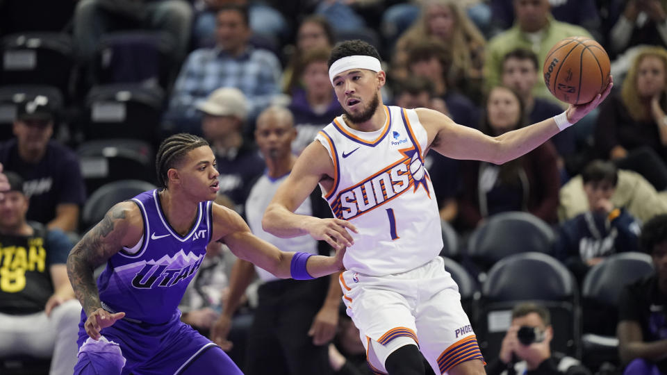 Utah Jazz guard Keyonte George, left, guards Phoenix Suns guard Devin Booker during the second half of an NBA basketball in-season tournament game Friday, Nov. 17, 2023, in Salt Lake City. (AP Photo/Rick Bowmer)