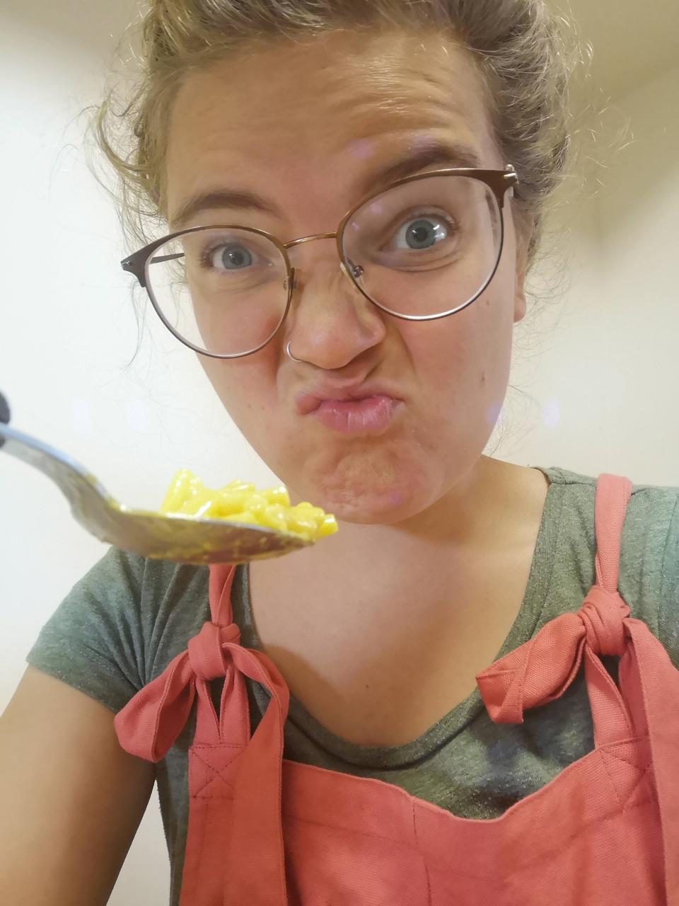 The author making a confused face with a spoonful of mac and cheese