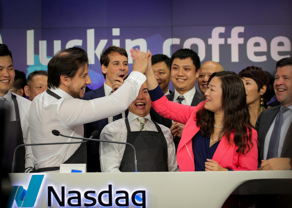 Jenny Qian Zhiya CEO of Luckin Coffee, exchanges high-five with an barista Andrea Lattuada during the company's IPO at the Nasdaq Market site in New York, U.S., May 17, 2019. REUTERS/Brendan McDermid