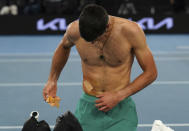 Serbia's Novak Djokovic takes a bandage off after defeating Russia's Daniil Medvedev in the men's singles final at the Australian Open tennis championship in Melbourne, Australia, Sunday, Feb. 21, 2021.(AP Photo/Mark Dadswell)