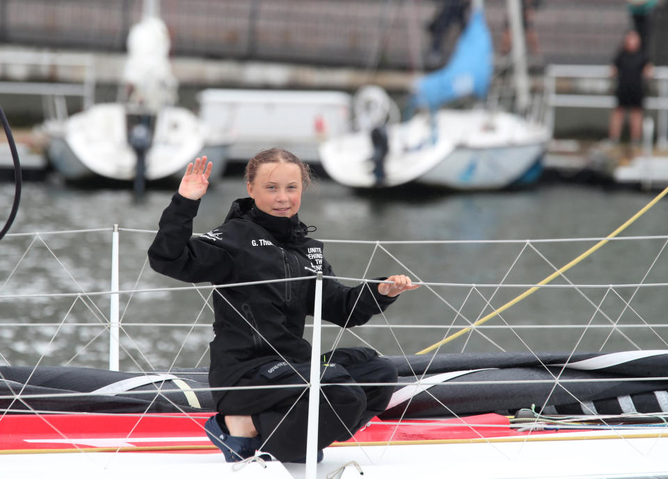 Greta Thunberg, a 16-year-old Swedish climate activist, waves after sailing in New York harbor aboard the Malizia II, Wednesday, Aug. 28, 2019. The zero-emissions yacht left Plymouth, England on Aug. 14. She is scheduled to address the United Nations Climate Action Summit on Sept. 23. (AP Photo/Mary Altaffer)