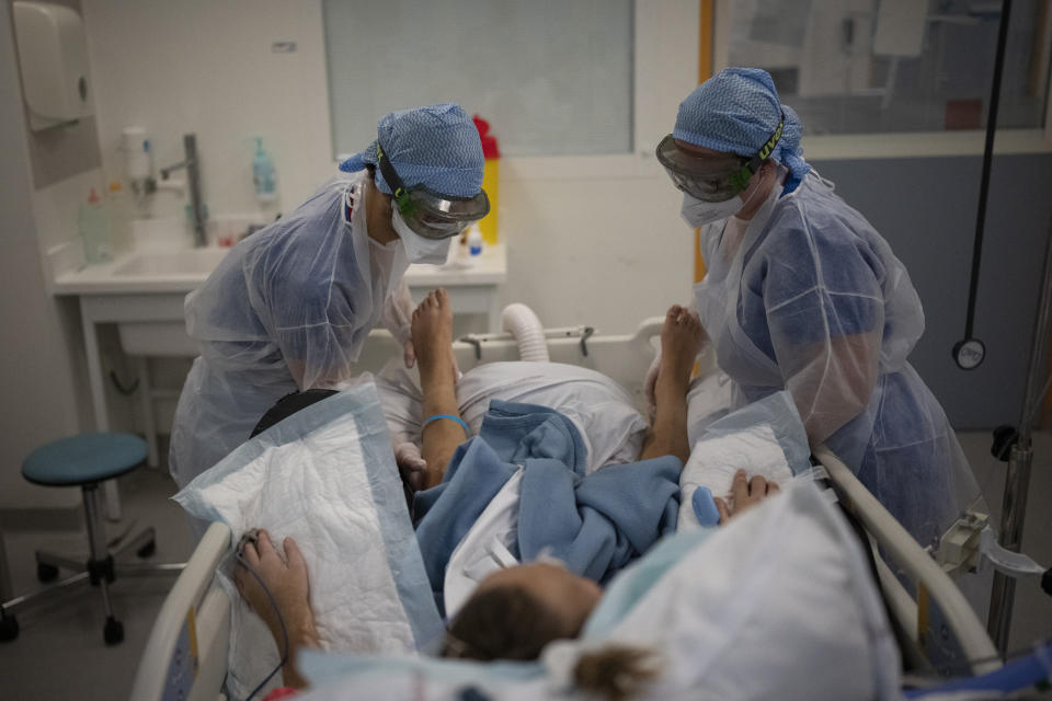 Nurses care for a COVID-19 patient in the COVID-19 intensive care unit at the la Timone hospital in Marseille, southern France, Friday, Dec. 31, 2021. Paris region health authorities have instructed hospitals to cancel more non-urgent medical procedures to free up intensive-care beds for the growing influx of people gravely sick with COVID-19. (AP Photo/Daniel Cole)