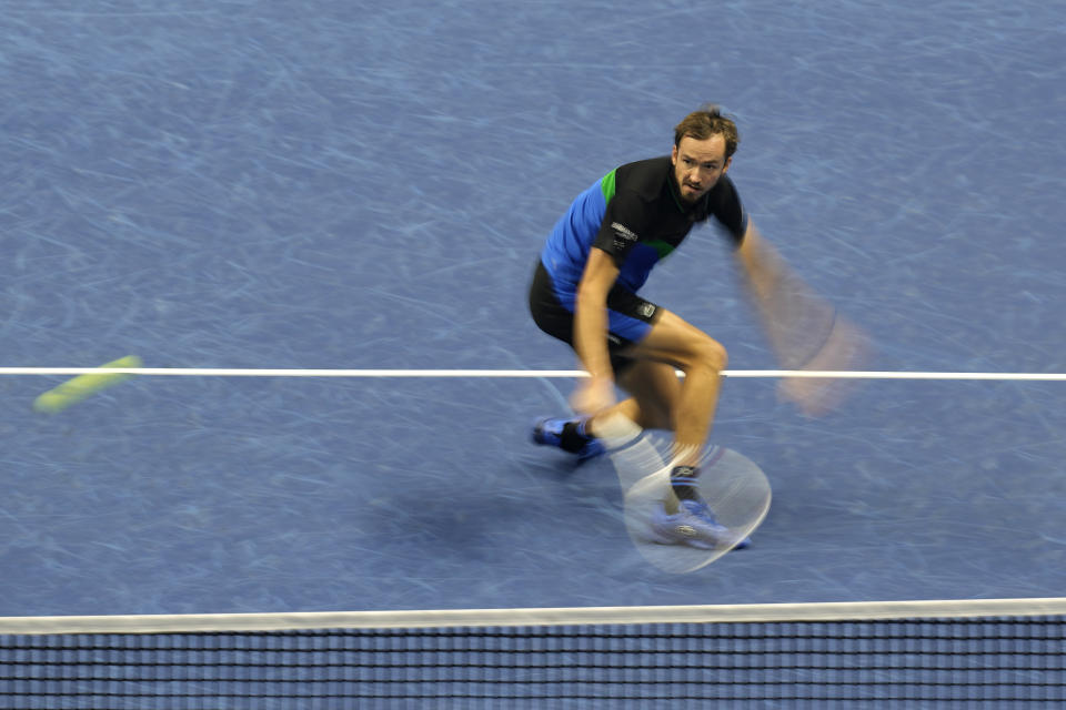 In this image taken with a slow shutter speed, Russia's Daniil Medvedev returns the ball to Spain's Carlos Alcaraz during their singles tennis match of the ATP World Tour Finals at the Pala Alpitour, in Turin, Italy, Friday, Nov. 17, 2023. (AP Photo/Antonio Calanni)