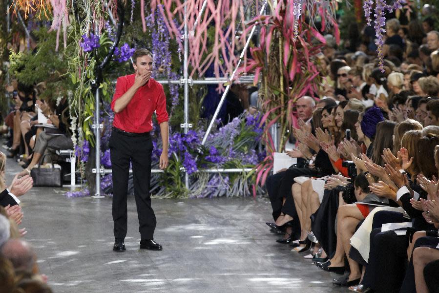 Belgian fashion designer Raf Simons blows a kiss to the audience as he acknowledges applause following the presentation of the ready-to-wear Spring/Summer 2014 fashion collection he designed for Christian Dior, Friday, Sept. 27, 2013 in Paris. (AP Photo/Christophe Ena)