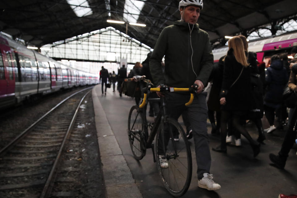 Commuters walk out of a train at the Gare Saint Lazare station in Paris, France, Monday, Dec. 16, 2019. French transport strikes against a planned overhaul of the pension system entered their twelfth day Monday as French president Emmanuel Macron's government remains determined to push ahead with its plans. (AP Photo/Francois Mori)