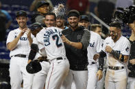 Florida Marlins players celebrate after Jazz Chisholm Jr. (2) scored the winning run during the 10th inning of a baseball game against the Washington Nationals, Monday, Sept. 20, 2021, in Miami. (AP Photo/Marta Lavandier)