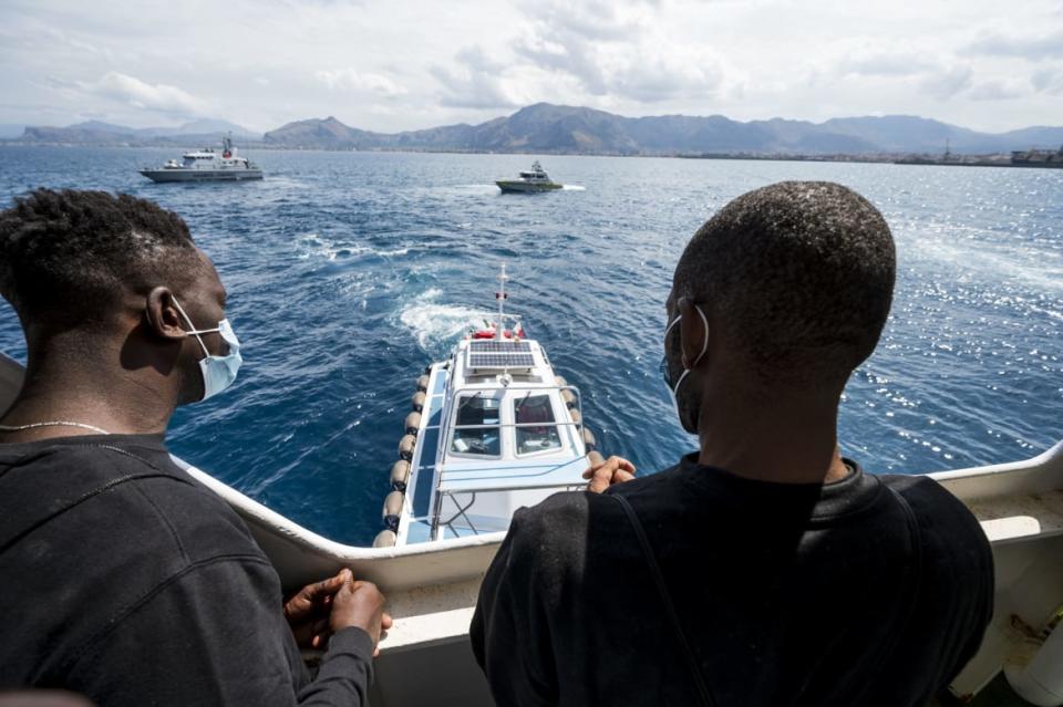 <div class="inline-image__caption"><p>Migrants on the Sea-Watch 4 sea rescue ship are seen off the coast of Palermo, Sicily, Italy, on September 02, 2020, as they approach a ferry where they will be under quarantine. </p></div> <div class="inline-image__credit">THOMAS LOHNES/AFP via Getty Images</div>