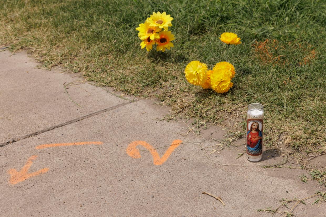 A votive candle sits next to a spray-painted evidence marker at the site of the deadly crash where eight migrants were run over and killed yesterday waiting at a bus stop on 8 May 2023 in Brownsville, Texas (Getty Images)