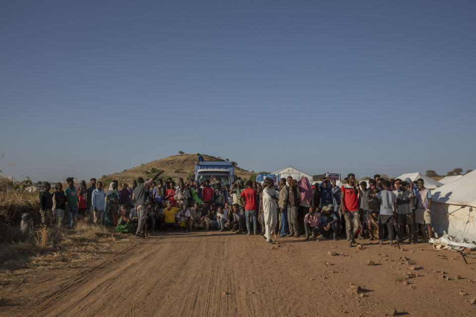 Tigray refugees who fled the conflict in Ethiopia's Tigray region, are ordered to organize themselves in line to receive aid at Umm Rakouba refugee camp in Qadarif, eastern Sudan, Tuesday, Nov. 24, 2020. (AP Photo/Nariman El-Mofty)