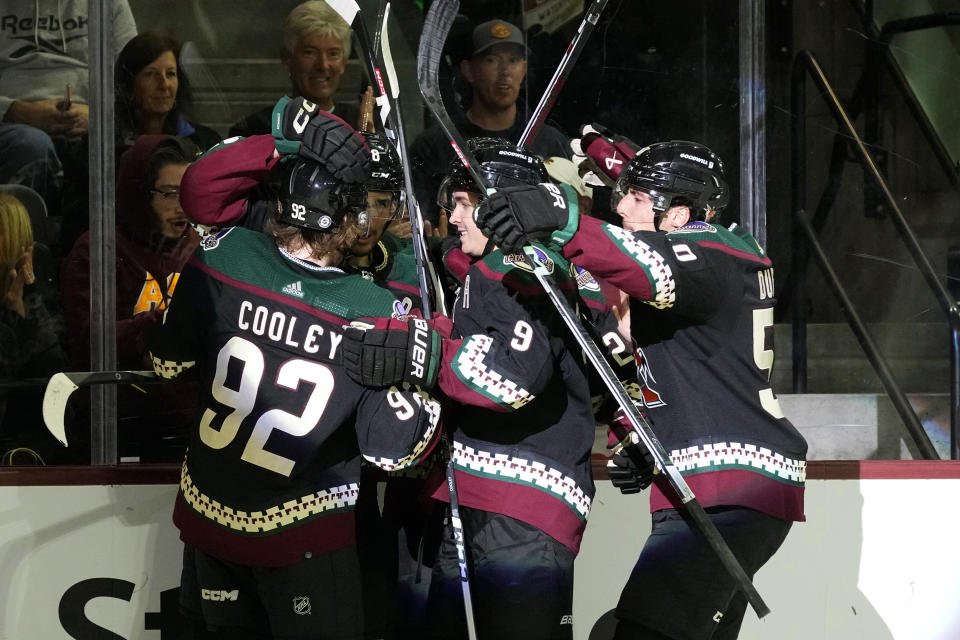 Arizona Coyotes center Nick Schmaltz (8) celebrates his goal against the Montreal Canadiens with center Logan Cooley (92), right wing Clayton Keller (9) and defenseman Sean Durzi, right, during the third period of an NHL hockey game Thursday, Nov. 2, 2023, in Tempe, Ariz. (AP Photo/Ross D. Franklin)