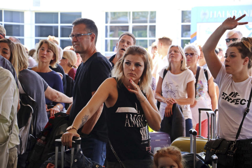 British passengers with Thomas Cook wait in queue at Antalya airport in Antalya, Turkey, Monday Sept. 23, 2019. Hundreds of thousands of travellers were stranded across the world Monday after British tour company Thomas Cook collapsed, immediately halting almost all its flights and hotel services and laying off all its employees. According to reports Monday morning some 21,000 Thomas Cook travellers were stranded in Turkey alone.(IHA via AP)