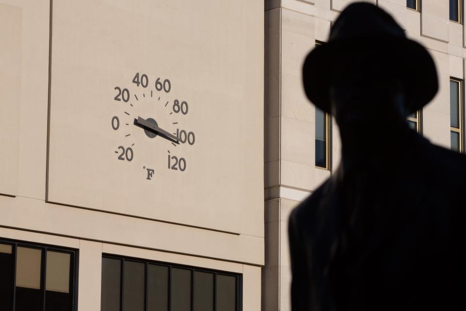 A mercury reading of more than 100 degrees is reflected Wednesday afternoon by the thermometer on the exterior of downtown Topeka's Evergy building, across S. Kansas Avenue from a statue of historic Topekan McKinley Burnett.