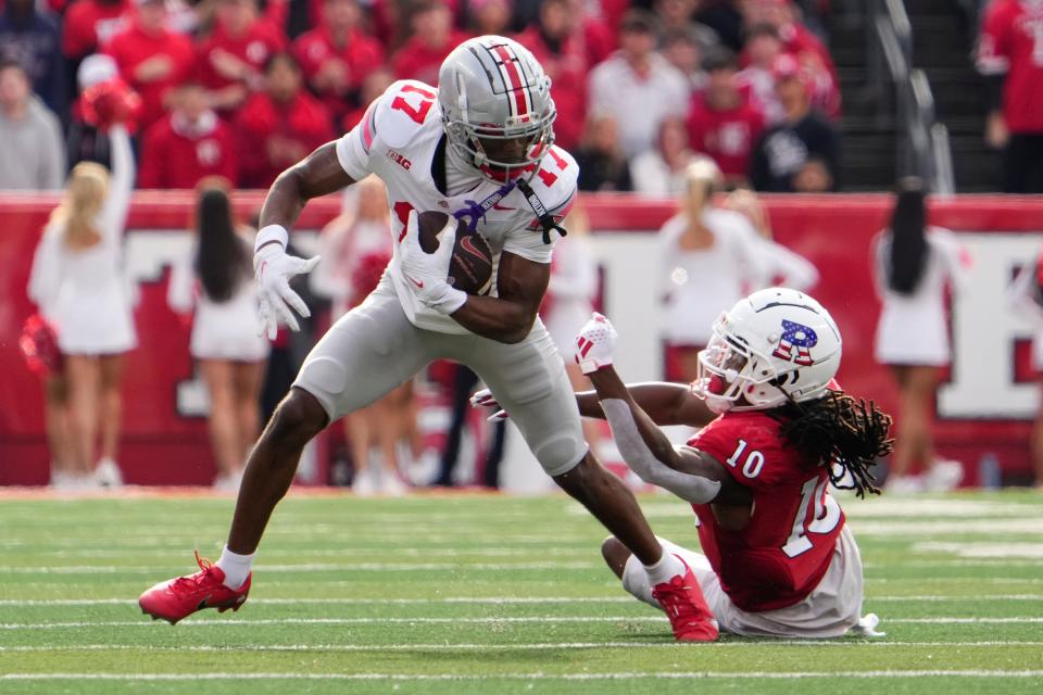 Nov 4, 2023; Piscataway, New Jersey, USA; Ohio State Buckeyes wide receiver Marvin Harrison Jr. (18) eludes a tackle by Rutgers Scarlet Knights defensive back Flip Dixon (10) during the NCAA football game at SHI Stadium. Ohio State won 35-16.