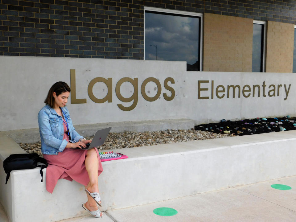 First-year teacher Cindy Hipps sits outside of Lagos Elementary School, at Manor Independent School District campus east of Austin, Texas where she has taught first grade in a virtual and in-person hybrid classroom during the COVID-19 pandemic. Hipps said she was told she "was introduced to the ring of fire of teaching." "I feel like a superwoman now, like I can take on anything.” (Acacia Coronado/Report for America via AP)