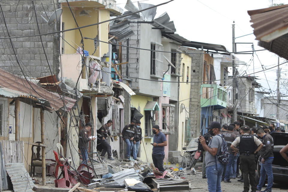 Police investigate the site of an explosion in the Cristo de El Consuelo neighborhood, in Guayaquil, Ecuador, Sunday, Aug. 14, 2022. According to the authorities a gunshot attack and subsequent explosion left at least five dead, 15 injured and several missing and affected homes. (AP Photo/ Magdalena Moreira)