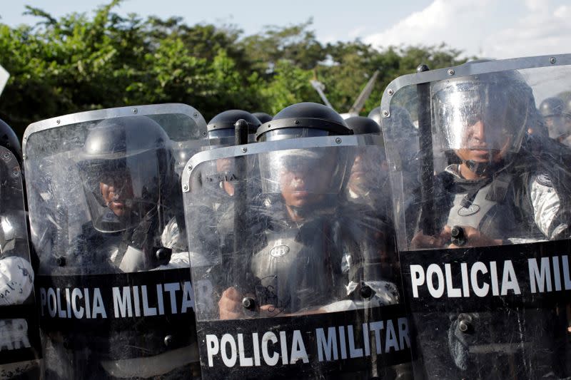 Security forces are seen as migrants march in a caravan near Frontera Hidalgo