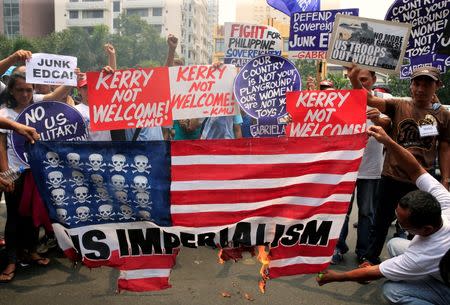 Protesters burn a replica of an American flag while denouncing the visit of U.S. Secretary of State John Kerry and the Supreme Court's decision to uphold, with finality, the constitutionality of the Enhanced Defense Cooperation Agreement (EDCA) during a protest outside the U.S. embassy in metro Manila, Philippines July 27, 2016. REUTERS/Romeo Ranoco