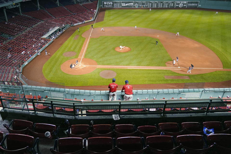 Two ushers watch the Boston Red Sox play the Atlanta Braves from nearly empty stands, after play in the Wednesday May 26 game was stopped for a rain delay, as play resumed in the seventh inning of a baseball game at Fenway Park, early Thursday, May 27, 2021, in Boston. (AP Photo/Charles Krupa)