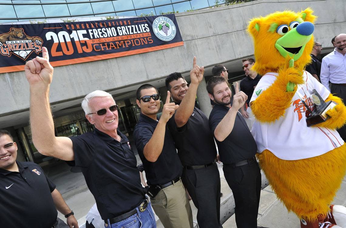 Chris Cummings, Fresno Grizzlies Managing General Partner/President, left, leads team staff and Parker in the ‘we’re number 1’ pose for pictures at City Hall, after a special ceremony honoring the Pacific Coast League and National Champion Fresno Grizzlies, Thursday morning. JOHN WALKER/THE FRESNO BEE Sept. 24, 2015