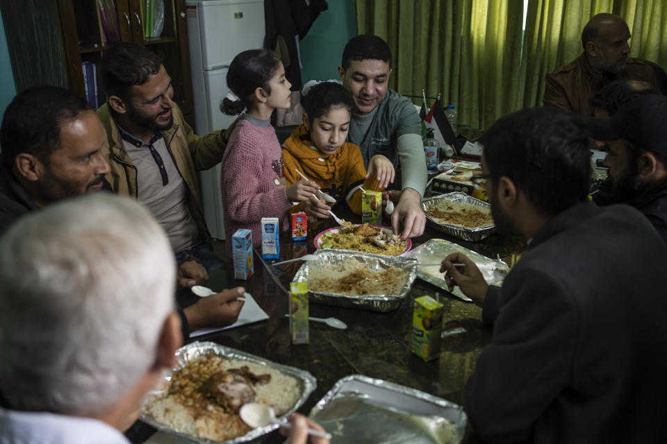 Dr. Suhaib Alhamss, the director of the Kuwaiti Hospital in Gaza's southern town of Rafah, takes a break to eat with his young daughters during their weekly visit to the hospital. Thursday, Jan. 11, 2024. Overwhelmed with the dead and wounded as Rafah's population swells with displaced people, Alhamss has struggled to save lives as his hometown and hopsital have transformed over the 100 days of the Israel-Hamas war. (AP Photo/Fatima Shbair)