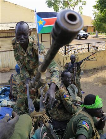 A South Sudan army soldier stands next to a machine gun mounted on a truck in Malakal town, 497km (298 miles) northeast of capital Juba, December 30, 2013 a few days after retaking the town from rebel fighters. REUTERS/James Akena