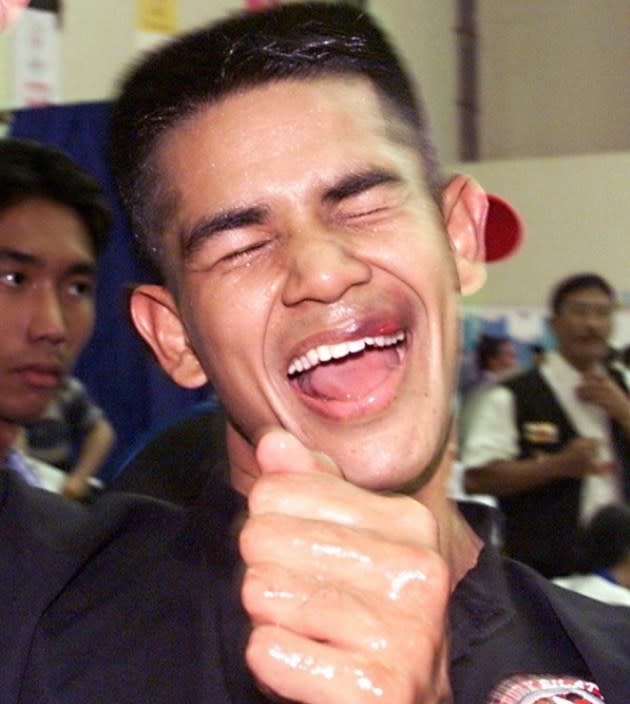 Abdul Kadir, sporting a fresh cut on his lip, celebrates after winning the gold medal at the Southeast Asian Games in 1999. (AFP Photo)