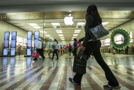 People walk past the Apple Store while shopping at the Los Cerreitos Center mall on Black Friday in Cerritos, California, November 23, 2012. REUTERS/Bret Hartman
