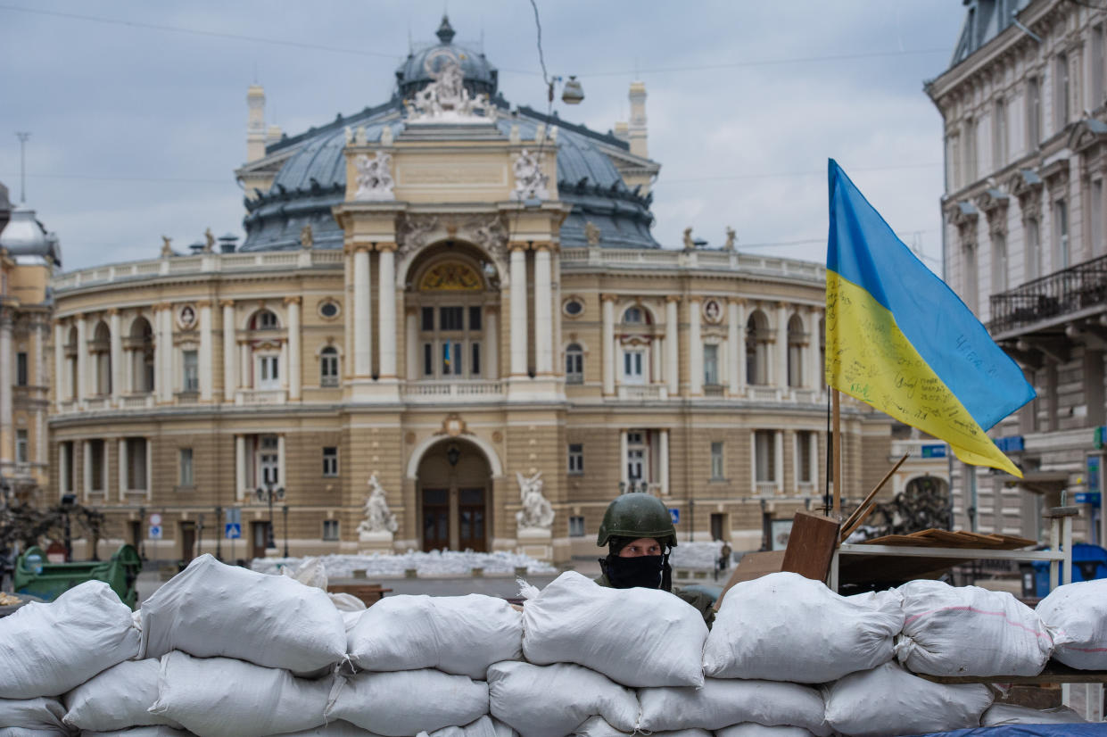 A soldier stands guard behind sandbags near the Odesa National Academic Opera and Ballet Theatre.