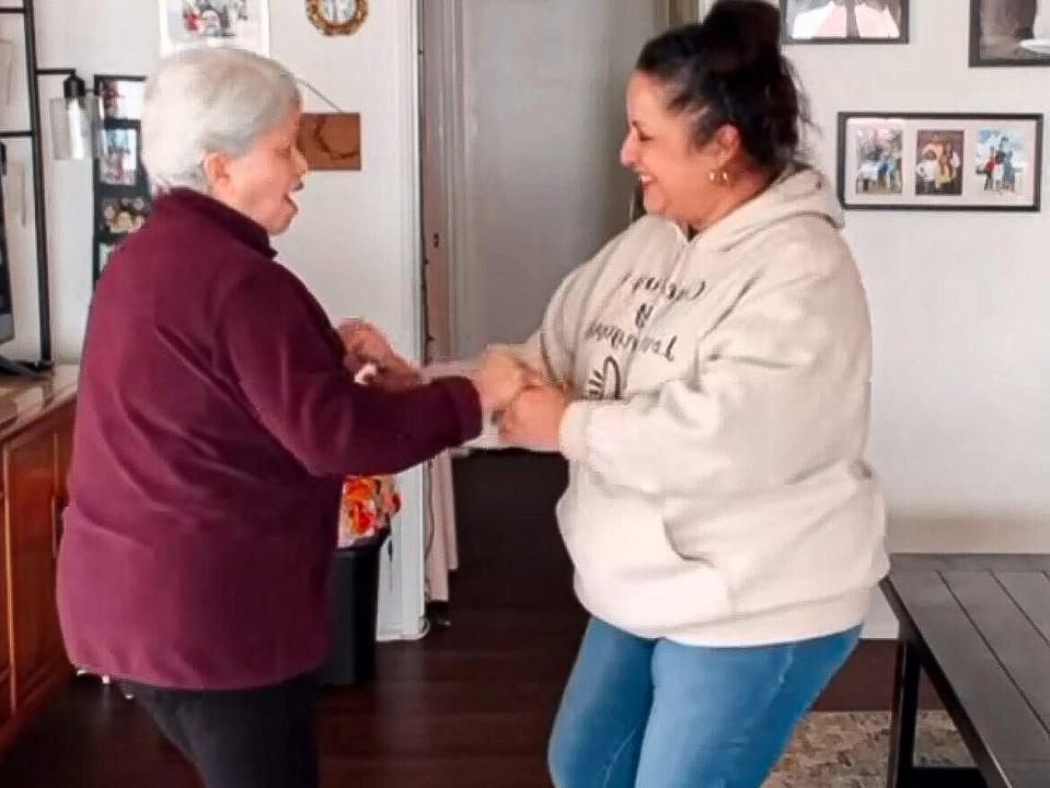 A mother and daughter holding hands dancing