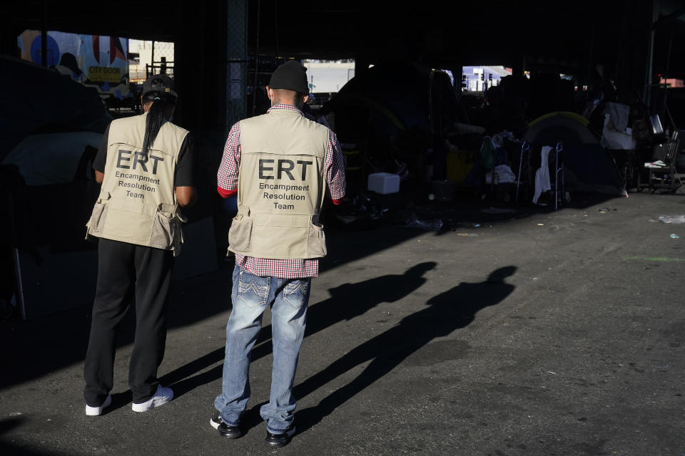 Members of the San Francisco Homeless Outreach Team's Encampment Resolution Team walk toward an encampment in San Francisco, Tuesday, Aug. 29, 2023. Cities across the U.S. are struggling with and cracking down on tent encampments as the number of homeless people grows, largely due to a lack of affordable housing. Homeless people and their advocates say sweeps are cruel and costly, and there aren't enough homes or beds for everyone. (AP Photo/Jeff Chiu)