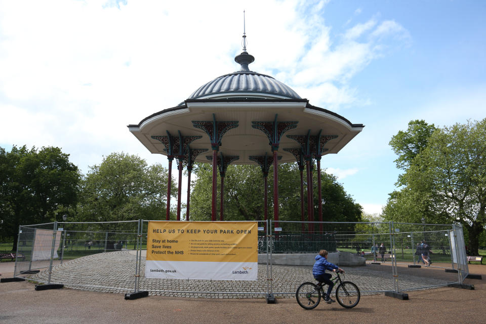 A young cyclist passes the closed off bandstand at Clapham Common, south London, as the UK continues in lockdown to help curb the spread of the coronavirus.