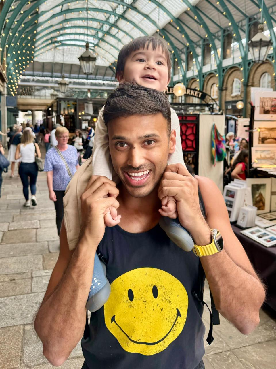 A man with a toddler on his shoulders in Covent Garden