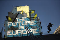 A child jumps next to a pro Europe street art painting in the European quarter in Brussels, Tuesday, July 23, 2019. Brexit champion Boris Johnson won the contest to lead Britain's governing Conservative Party on Tuesday and will become the country's next prime minister, tasked with fulfilling his promise to lead the U.K. out of the European Union. (AP Photo/Francisco Seco)