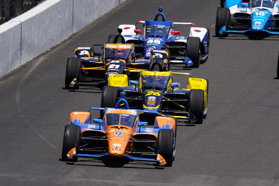 Scott Dixon, of New Zealand, leads the field into the first turn at the start the Indianapolis 500 auto race at Indianapolis Motor Speedway in Indianapolis, Sunday, May 30, 2021. (AP Photo/Paul Sancya)