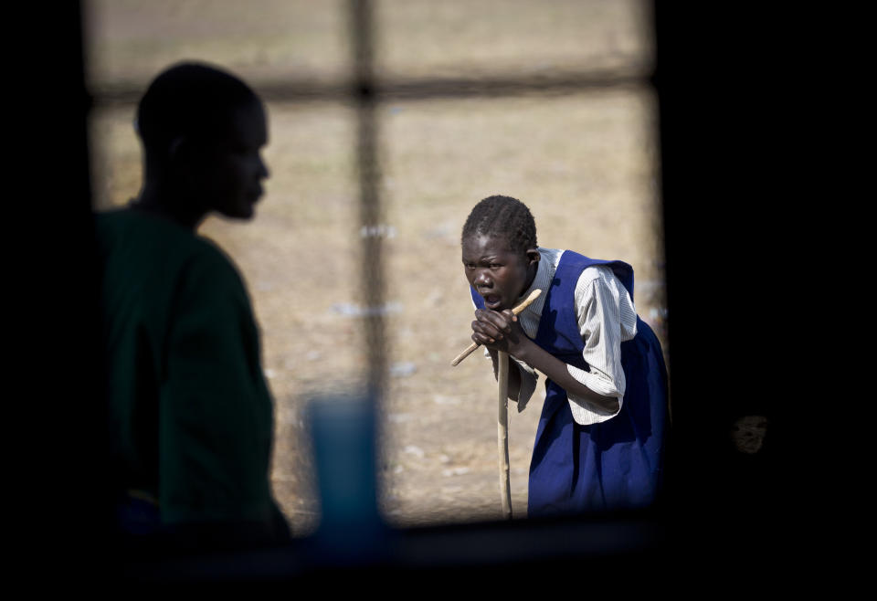 In this photo taken Thursday, Jan. 2, 2014, a girl waits outside a clinic run by Medecins Sans Frontieres (Doctors Without Borders) set up in a school building in the town of Awerial, South Sudan. (AP Photo/Ben Curtis)