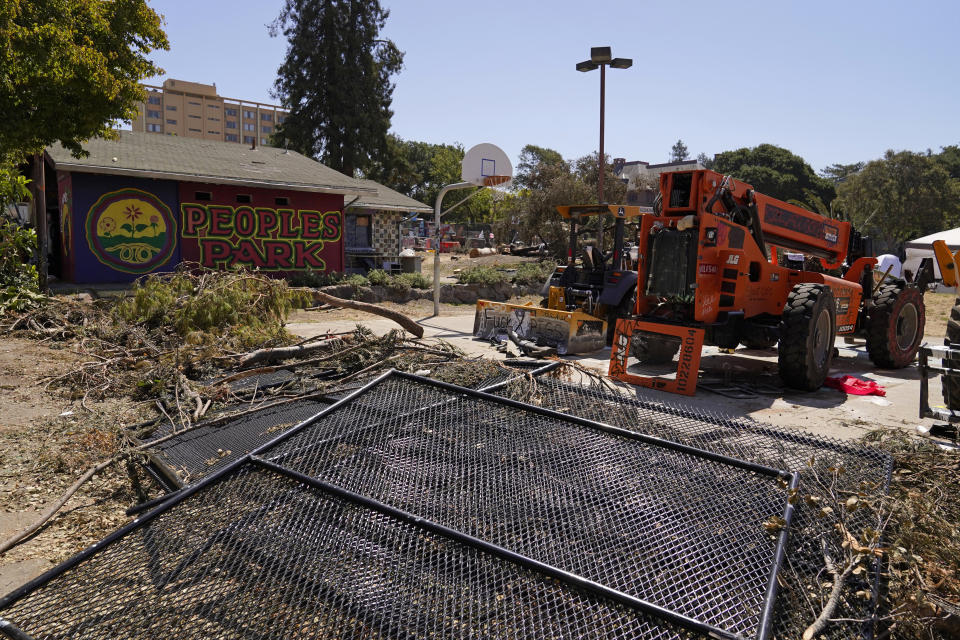 Fallen fences and graffiti-covered construction equipment left behind sit at People's Park in Berkeley, Calif., Tuesday, Aug. 16, 2022. The three-acre site's colorful history, forged from University of California, Berkeley's seizure of the land in 1968, has been thrust back into the spotlight by the school's renewed effort to pave over People's Park as part of a $312 million project that includes sorely needed housing for about 1,000 students. (AP Photo/Eric Risberg)