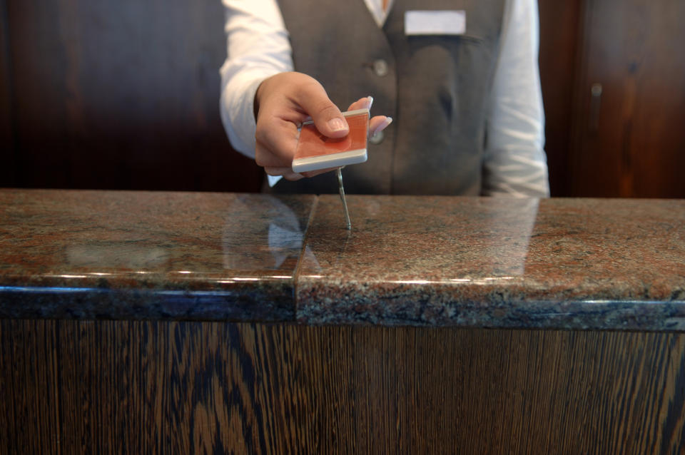 Hotel receptionist handing a key card over the counter
