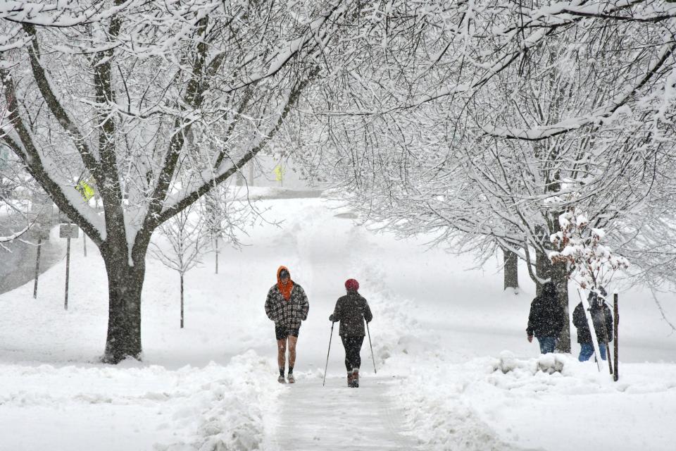 People trek in the snow along Main Street on the Williams College campus in Williamstown, Mass., on Monday morning, as the region received its first significant snowfall of the season and the year.