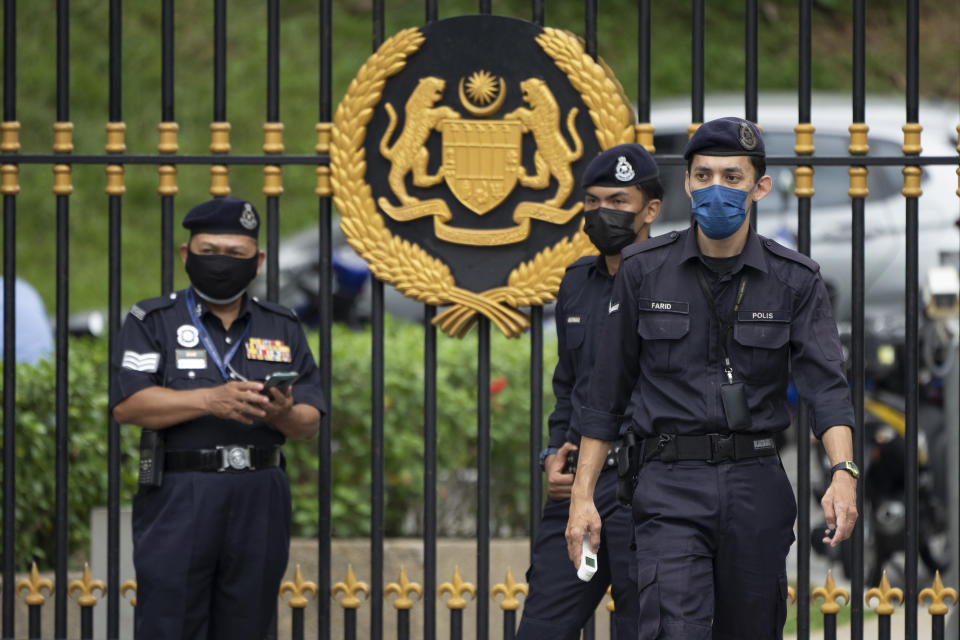 Police officers wearing face masks guard outside National Palace in Kuala Lumpur, Malaysia, Thursday, June 10, 2021. (AP Photo/Vincent Thian)