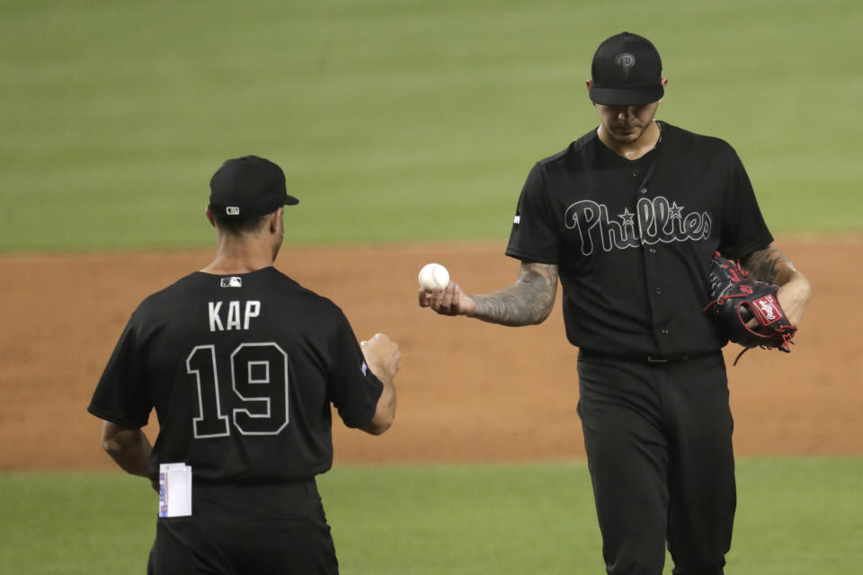 Philadelphia Phillies starting pitcher Vince Velasquez, right, hands the ball to manager Gabe Kapler as he is relieved during the third inning of a baseball game against the Miami Marlins, Friday, Aug. 23, 2019, in Miami. (AP Photo/Lynne Sladky)