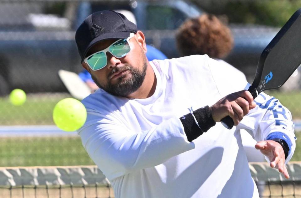 Dario Alfaro returns the ball in a doubles pickleball game at Rotary East Park Wednesday morning, June 21, 2023 in Fresno. Although surrounding towns have dedicated pickleball courts, Fresno and Clovis area fans of the game must share the use of tennis courts with added pickleball lines.