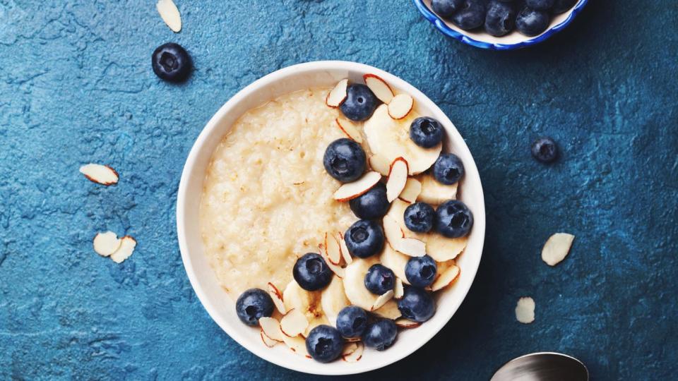 oatmeal porridge with banana and blueberry on vintage table top view in flat lay style